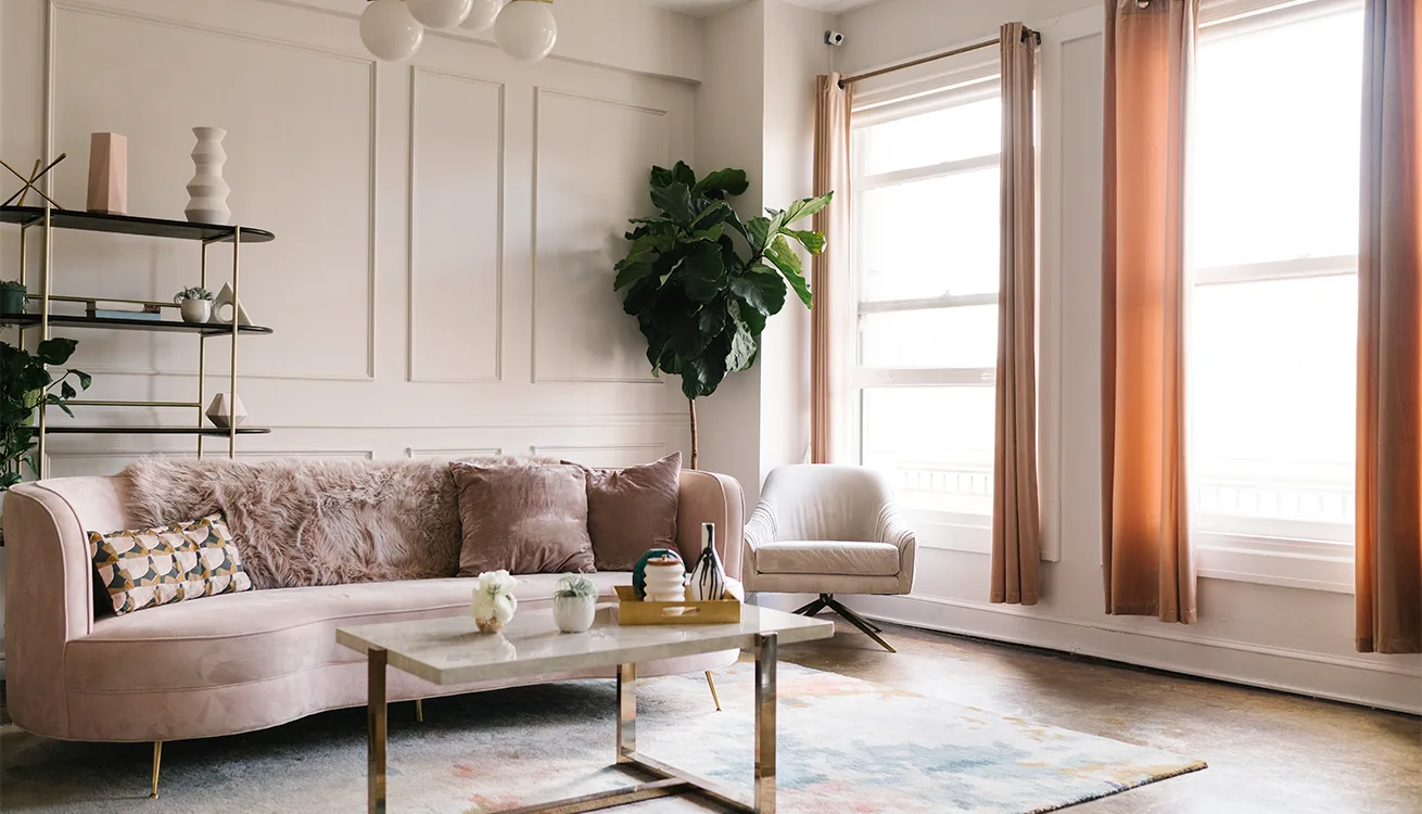 Lounge with a soft pink sofa and large windows